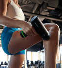 Person bruger Hypervolt Go 3 på benet i fitnesscentret
