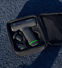Hypervolt Go 3 med grønt batterilys i et sort etui