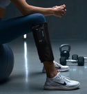Person, der sidder i fitnesscentret med Normatec Lower Legs
